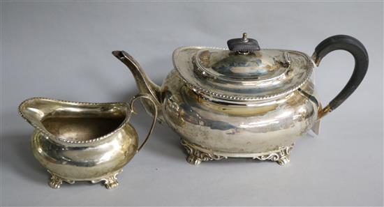 An Edwardian silver teapot and cream jug, gross 25 oz.